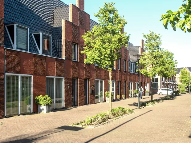 Praxisgebäude an der Auwiesenstrasse in Rüti, Backsteinbau mit Bäumen und gepflastertem Vorplatz
